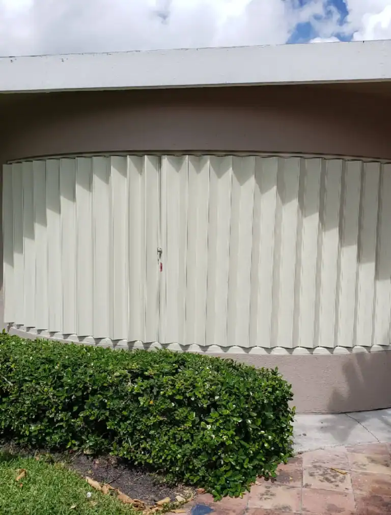 Custom curved accordion hurricane shutters fitted to bay window