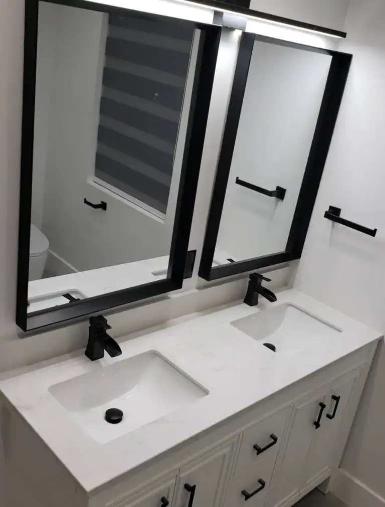 Modern bathroom renovation with double vanity, quartz countertop, and black fixtures