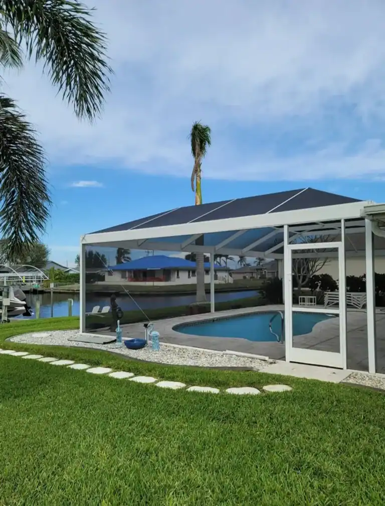 White aluminum screen enclosure covering backyard pool in Florida